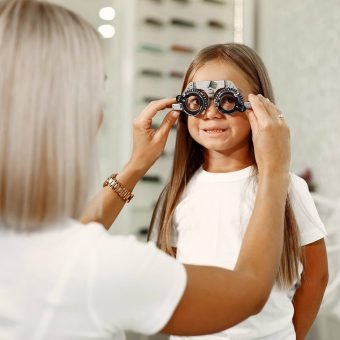 child-eye-test-and-eye-exam-little-girl-having-eye-check-up-with-phoropter-doctor-performs-eye-test-for-child
